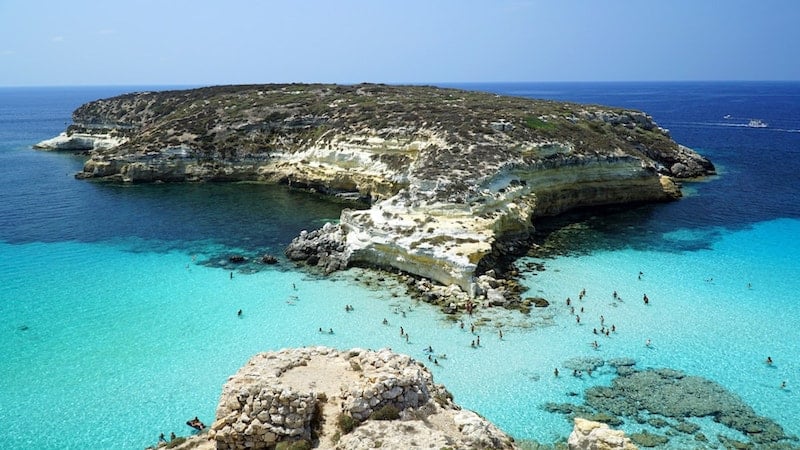 People swimming in the turquoise waters of Rabbit Beach, Lampedusa