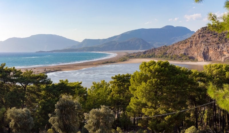 Long spit of sand at Iztuzu Beach, trees in foreground.