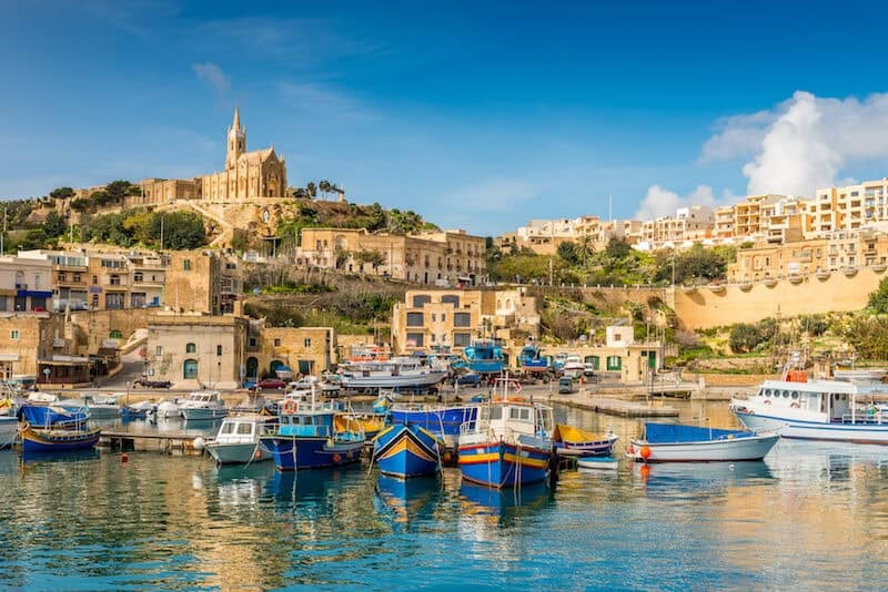golden harbour with colourful boats on Gozo