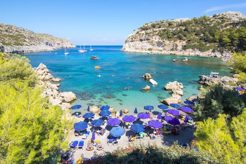 purple parasols on Anthony Quinn beach
