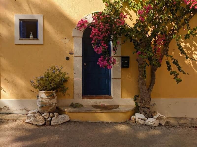 Yellow house with blue door in Assos
