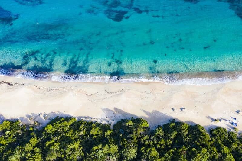 Overhead drone image of a white sand beach on the Costa Smeralda.