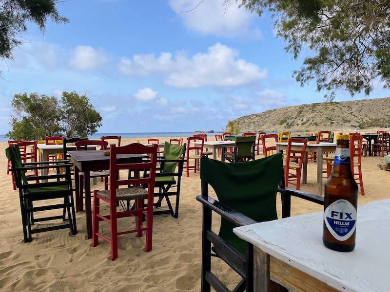 A Fix bottle on an empty beach taverna table.