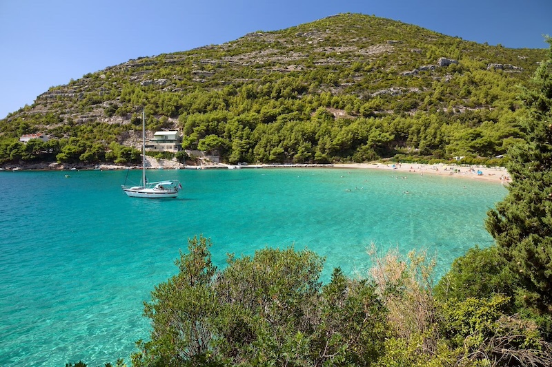 A yacht anchored in an emerald bay in Pelješac.