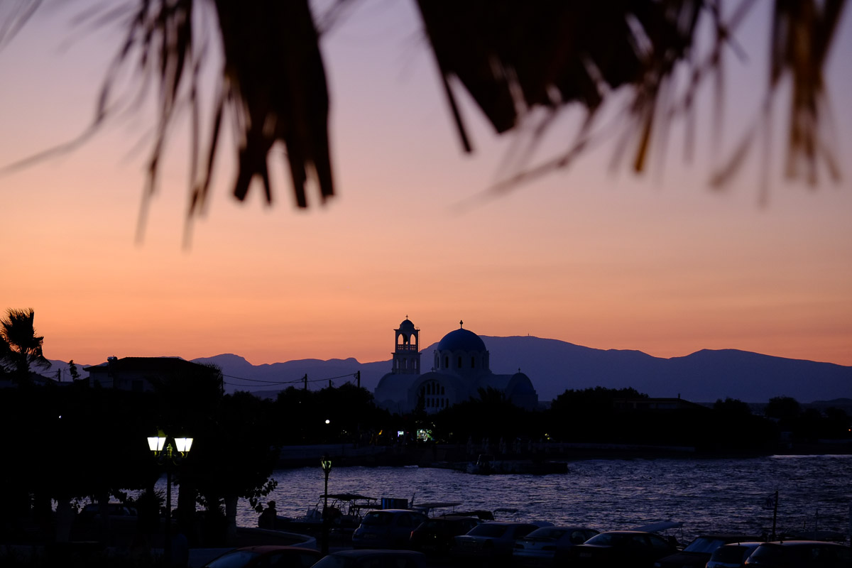The sun goes down behind Skala and the Church of Agioi Anargyroi.