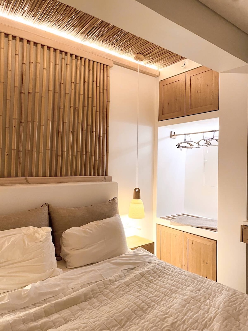 Bed area at Aktaion Boutique Hotel, with bamboo details behind the bed.