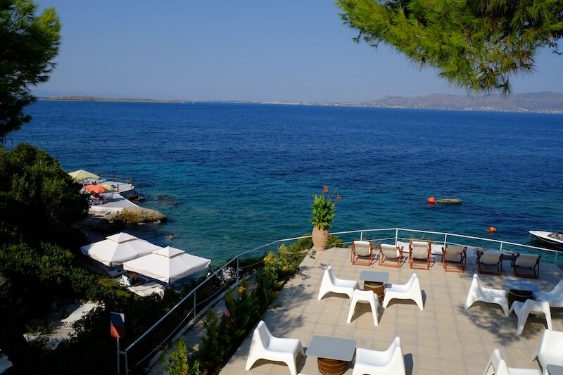 Deck next to the sea with cafe seating and sun loungers at Rosy's Little Village.