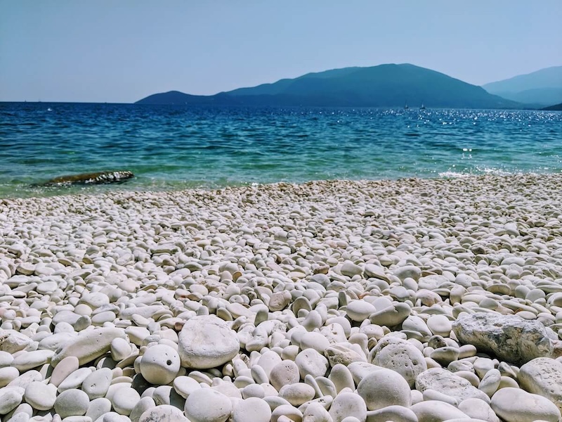 Smooth white pebbles at Lithovatis beach.